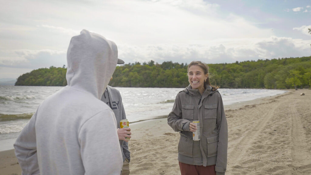 People standing on the beach, drinking, talking