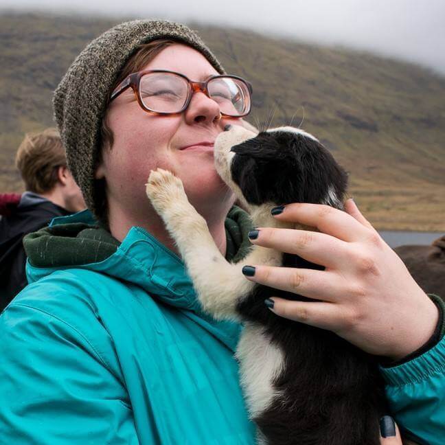 Hannah holding a black & white puppy