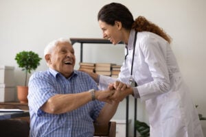 A female doctor meeting with a patient of hers, an older gentleman sitting down.