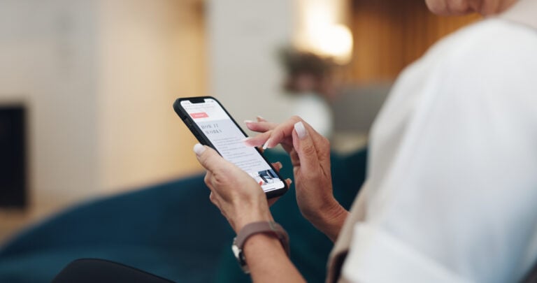 Woman holding iPhone looking at a retargeting ad