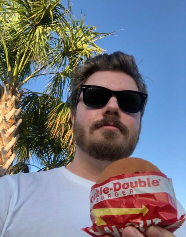 Picture of Andrew Allen holding a cheeseburger