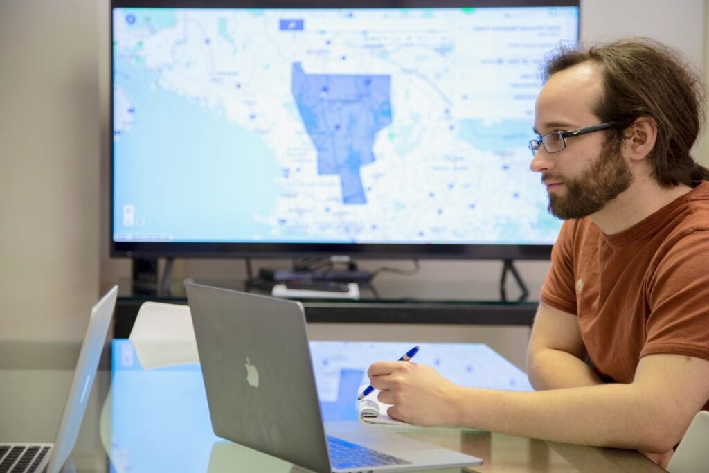 Website support engineer working on laptop at a table