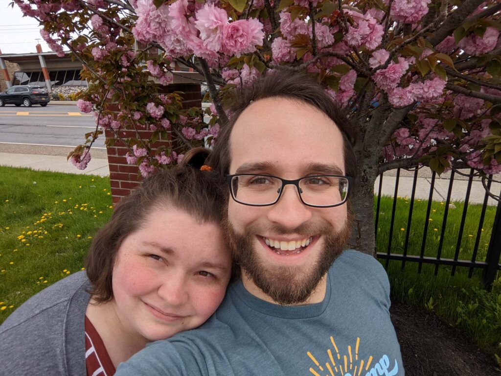 Aaron posing in front of some cherry blossoms