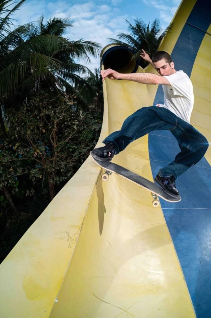 a man doing a skateboard trick at an abandoned water park