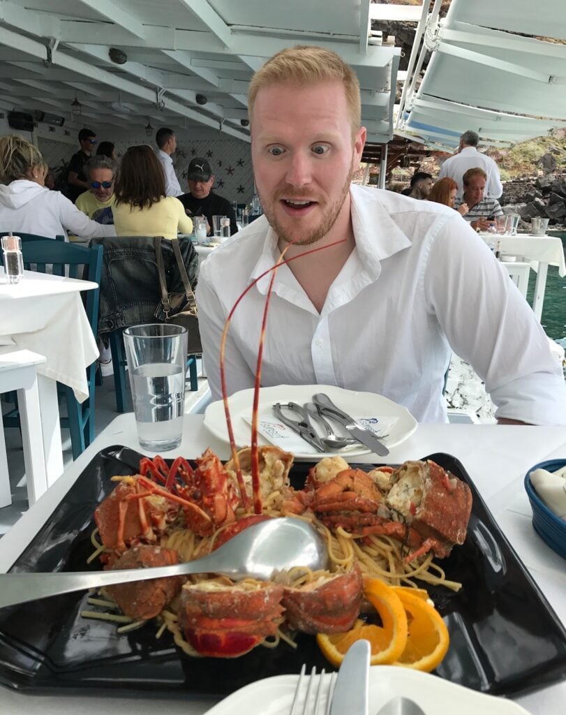 Josh in front of a large seafood dish at a restaurant