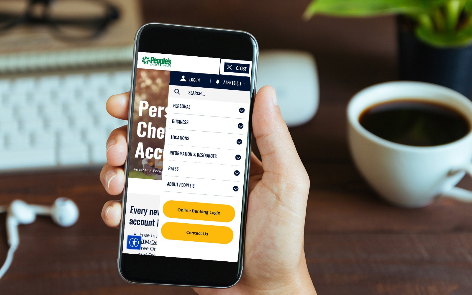Person holding a phone with the people's credit union mobile menu opened