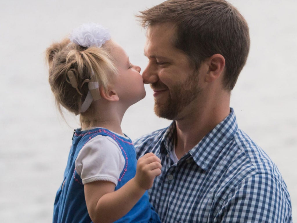 Little girl kissing father on the nose